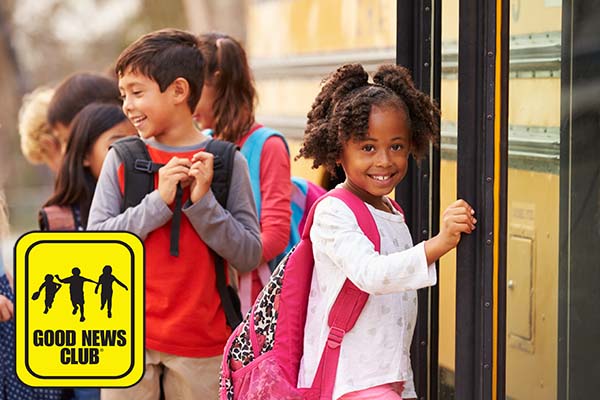 Child in line at school bus with GNC logo